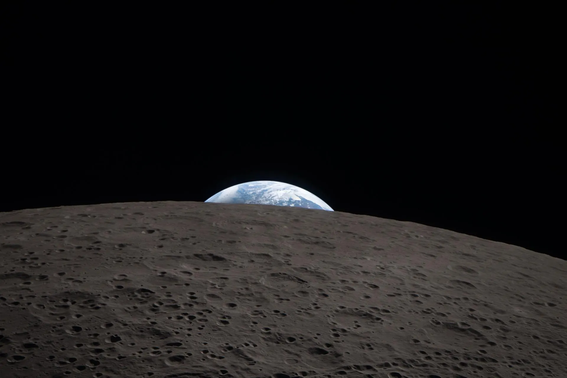 Earth setting behind the lunar horizon, seen from the Orion spacecraft